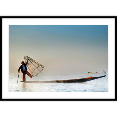 Ingelijste poster van een Aziatische man op een vissersboot met een visnet in zijn handen.