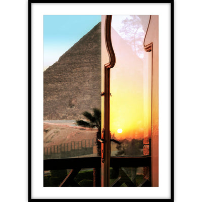 Een poster van een weerspiegelende zonsondergang in een glazen deur met op de achtergrond een piramide.