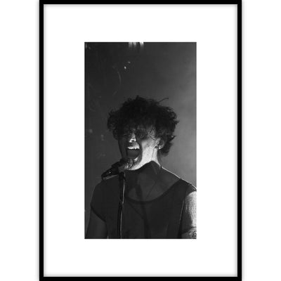 Een ingelijste poster met een zwart-wit portret van een muzikant die zingt in een microfoon.
