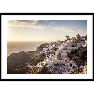 Een poster met een uitzicht over Santorini vanuit de bergen met daarin witte huisjes, molens en een zonsopgang.